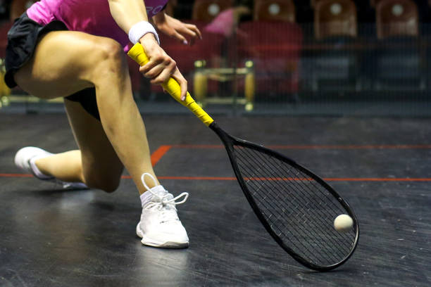 Human hand playing squash in the court